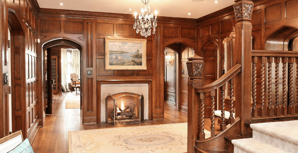 An elegant wood paneled entryway with a fireplace and chandelier