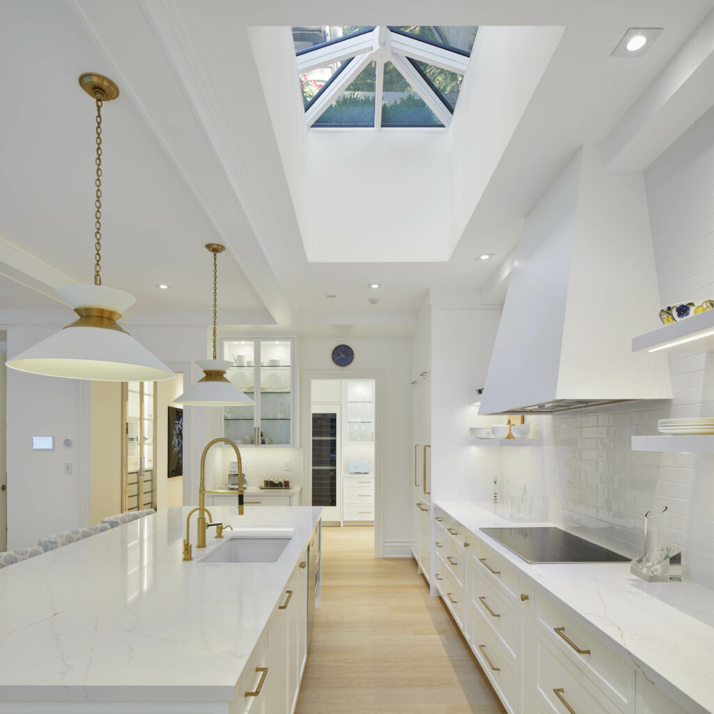 An elegant white kitchen with grass accents and a dome skylight